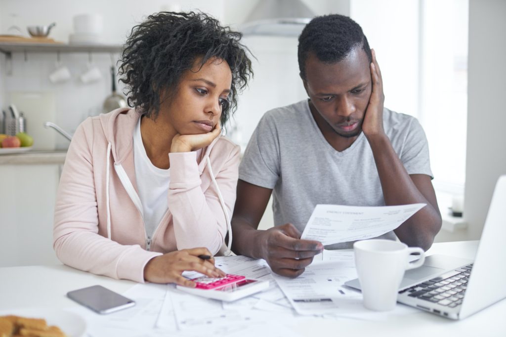 Unhappy couple having no money to pay off their debts, managing budget together